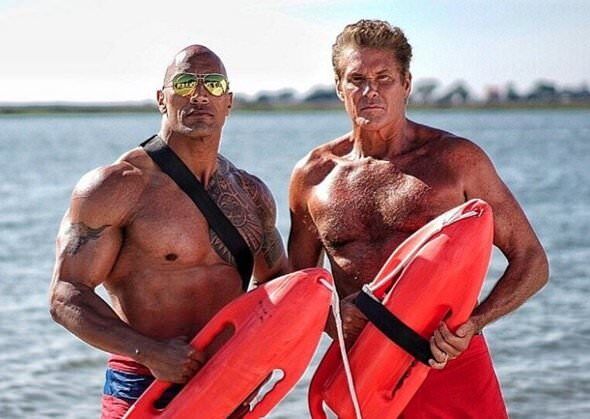 Dwayne Johnson and David Hasselhoff in Baywatch shorts by the beach