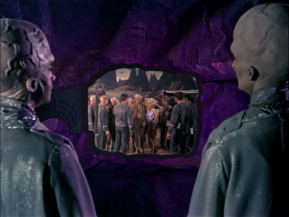 Two Talosians secretly watch and manipulate the Enterprise's away team