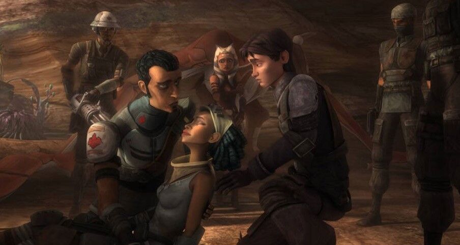 Saw Gerrera kneels down and holds his dying sister.