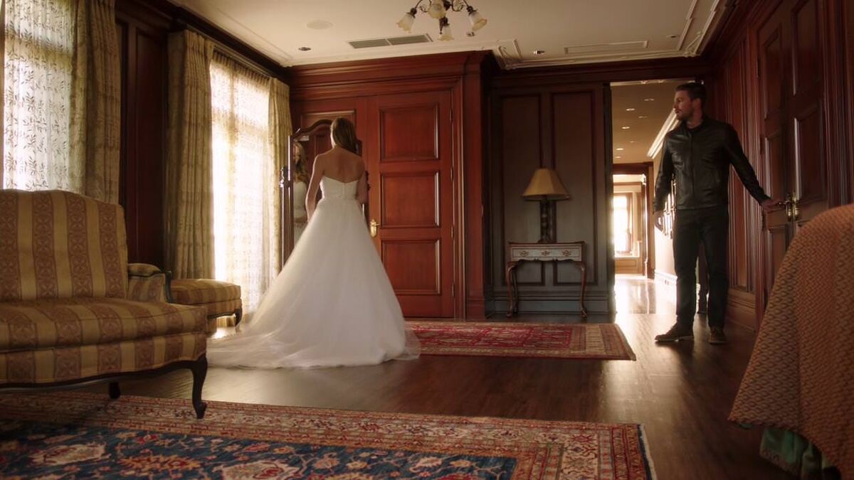 Laurel looking in mirror wearing wedding dress, Oliver entering the room to elope 