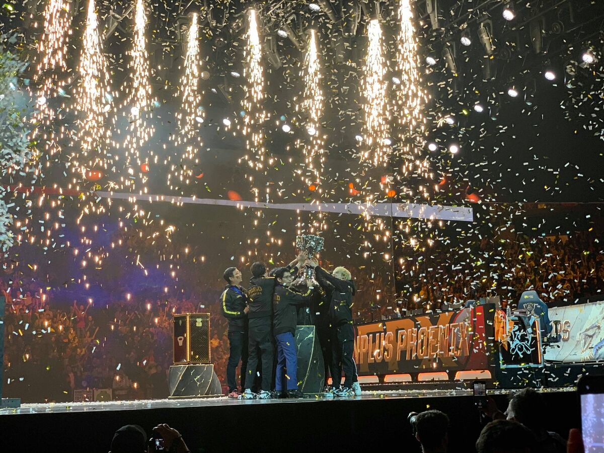 A team of five players holds up a large trophy.