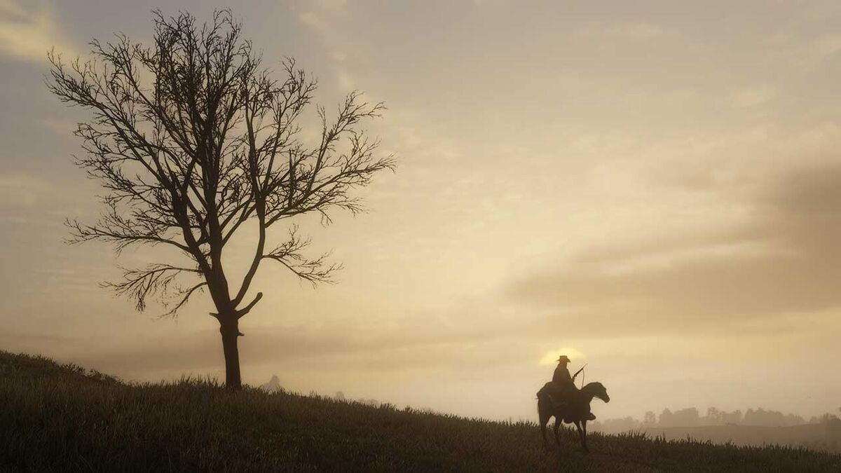 A horserider stands near a tall tree.