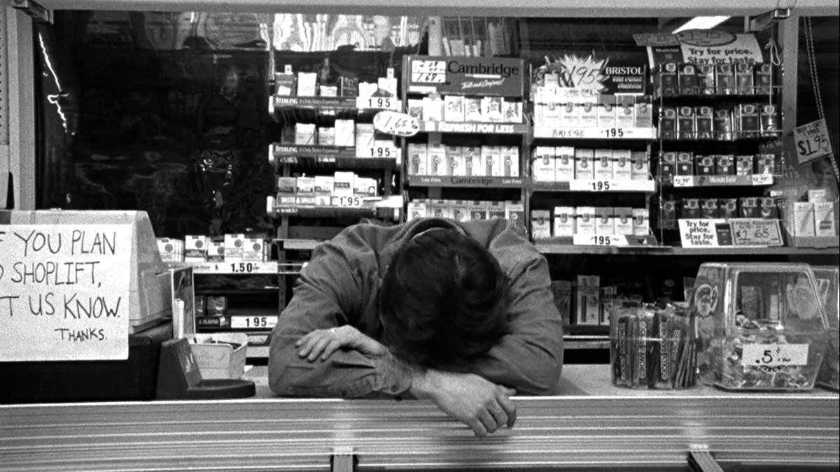 clerks convenience store fed up and laying his head on the counter