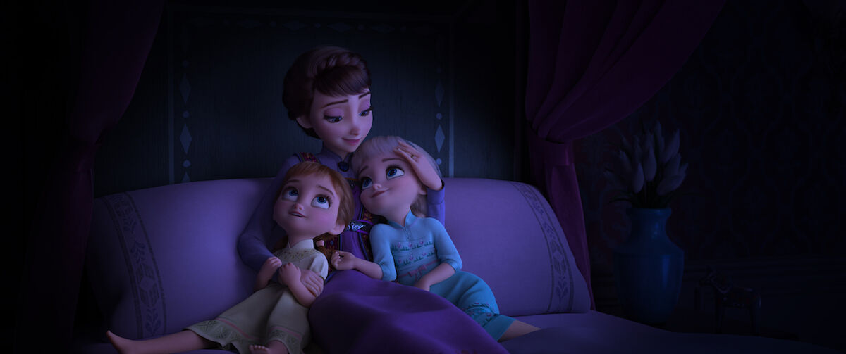 Young Elsa and Anna being sung to by their mother