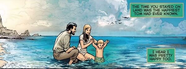 Child Aquaman and parents playing in water by the beach
