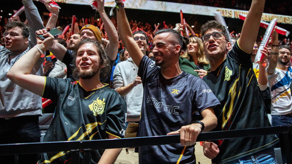 Three French fans raise their hands in the air.