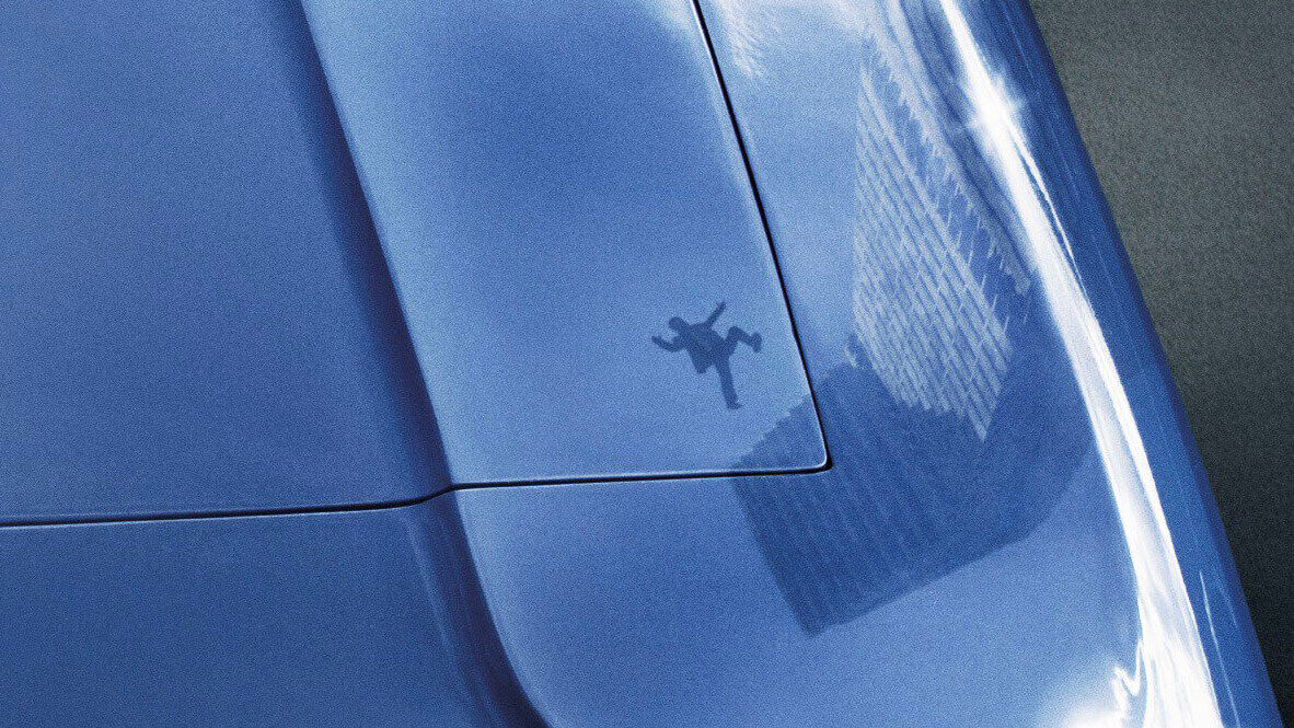 high rise shadow in shiny blue car of man falling from high rise building