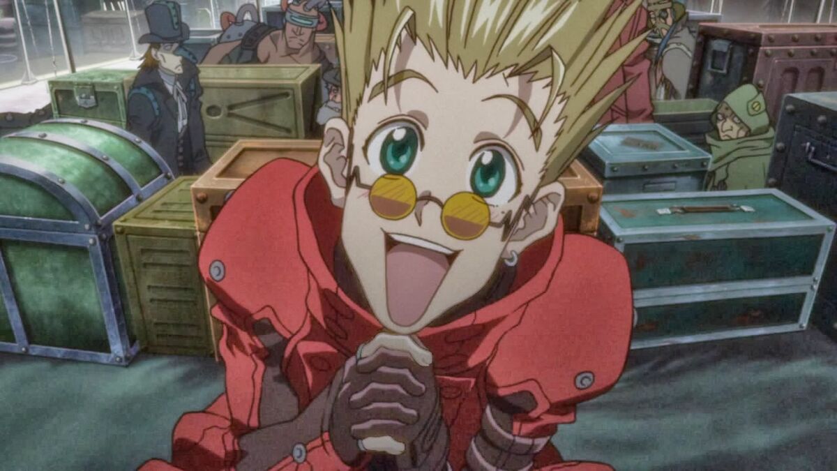 Vash with his hands clutched,  puppy-dog eyes, spiked blonde hair, green eyes, and red trench coat