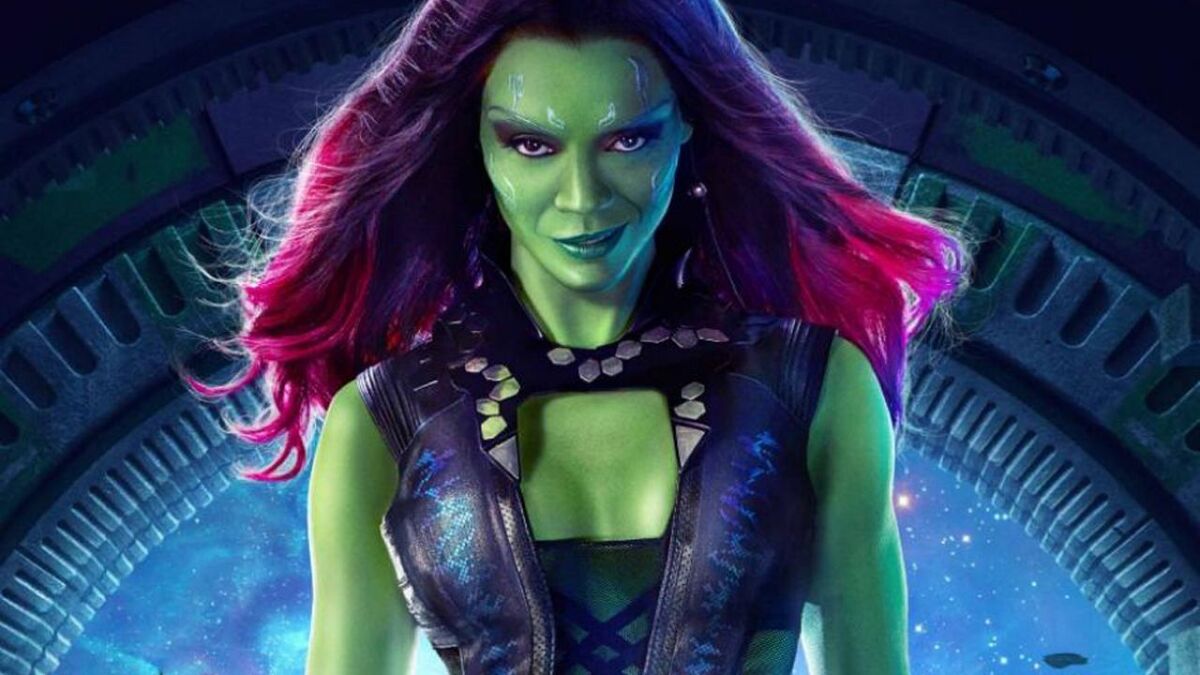 Green-skinned Gamora with fuschia-colored hair smirks at the camera.