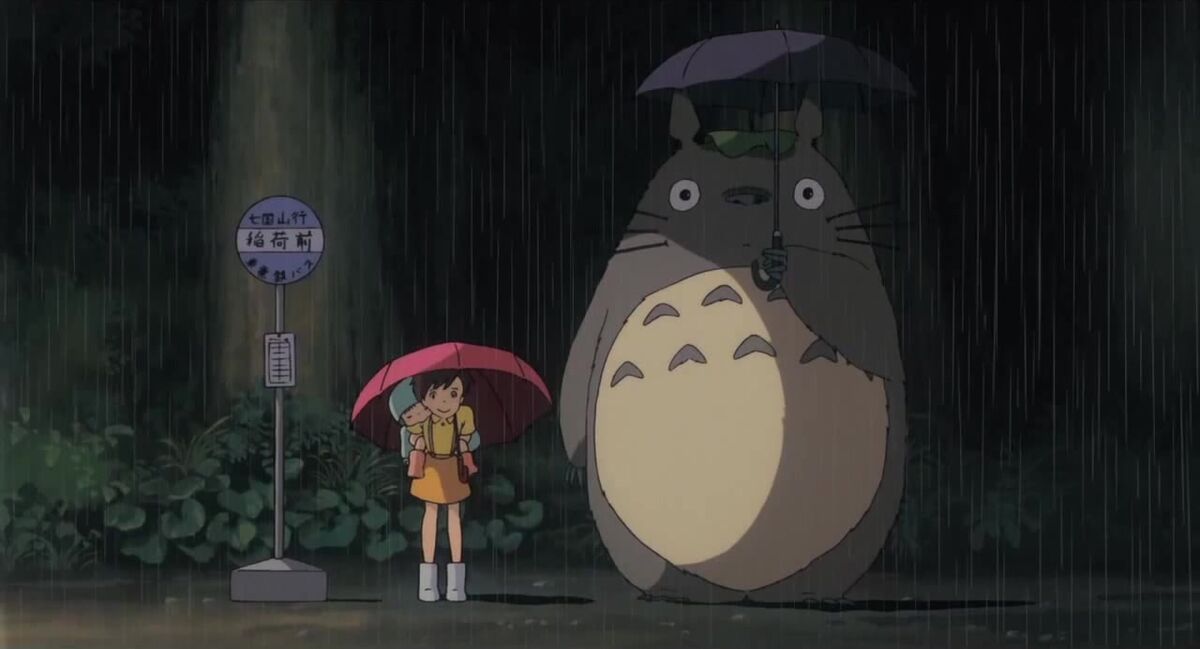 Satsuki, Mei, and Totoro waiting at the bus stop.