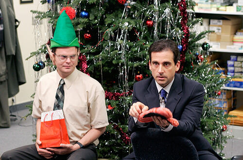 The Office christmas party episode Dwight as an elf and Michael holding oven mitt