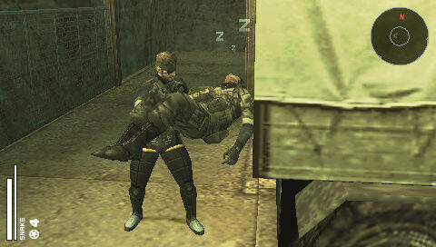 Snake loads a sleeping soldier into a truck in Metal Gear Solid: Portable Ops.