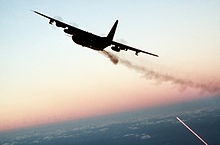 AC-130 gunship firing broadside at dusk