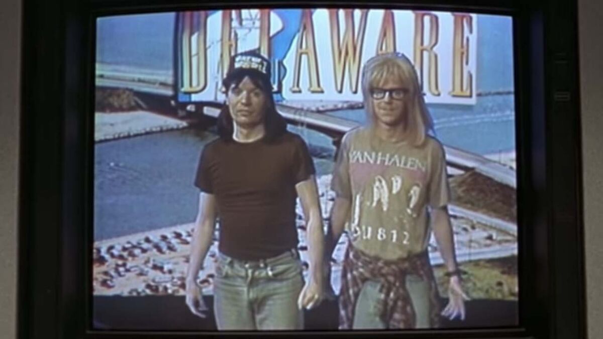 Wayne and Garth stand in front of a green screen showing Delaware.