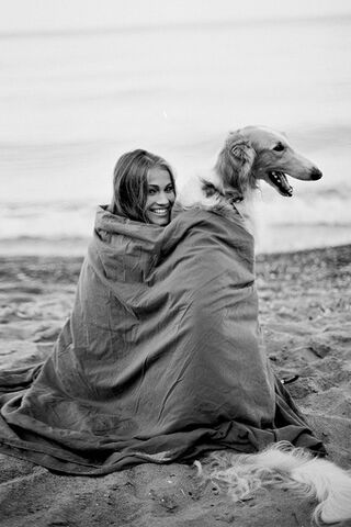 File:A girl and long haired dog wrapped up in a blanket on the beach.jpg
