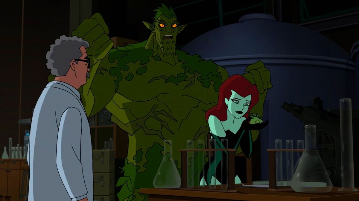 Poison Ivy looks lovingly at a mutated plant she's developed in a lab, behind her Swamp Thing is getting pumped.