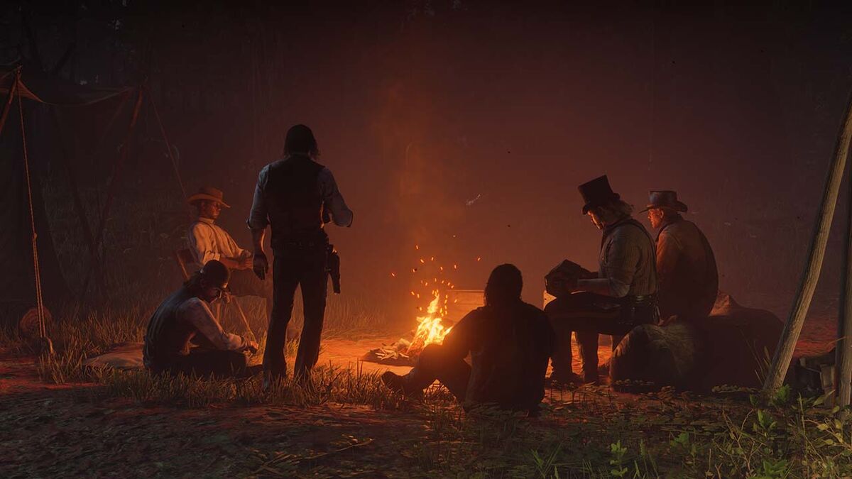 Red Dead Redemption 2&#039;s Van der Linde Gang members around a campfire.