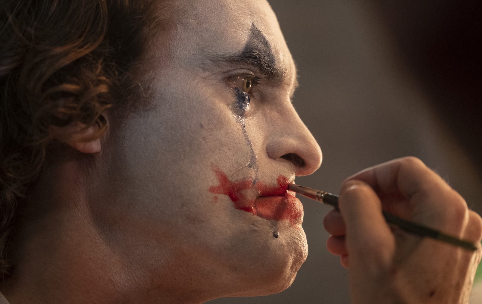 A film still showing Arthur putting his makeup on while crying