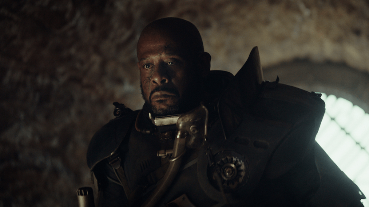 An older Saw Gerrera looks at Jyn with distrusting eyes.
