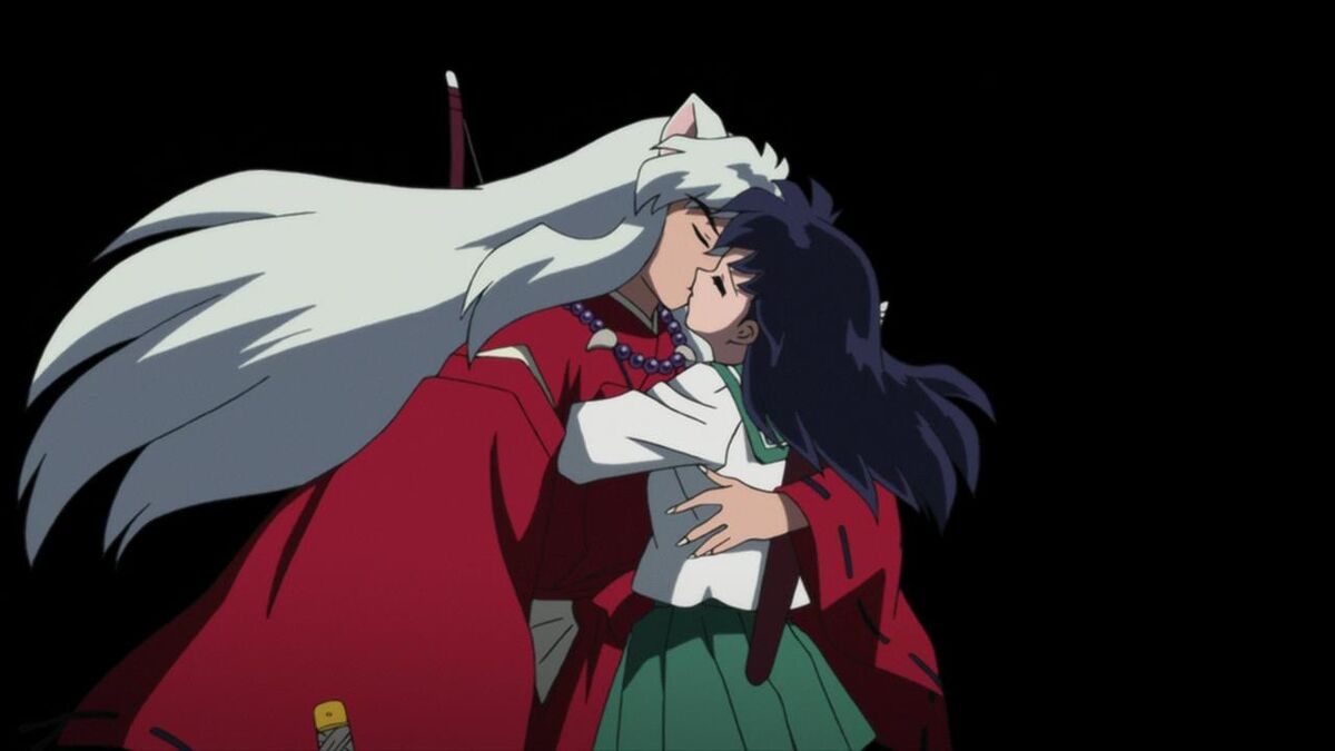Inuyasha's long white hair flows behind him as he embraces Kagome for a kiss