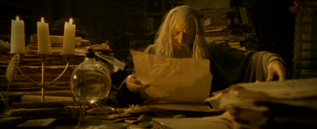 picture of long bearded wizard reading stack of books and manuscripts