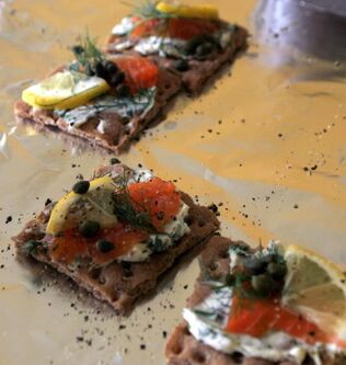 Gravlax on crackers with pepper and lemon