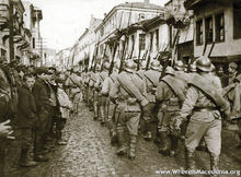 Regulars marching through a narrow village road