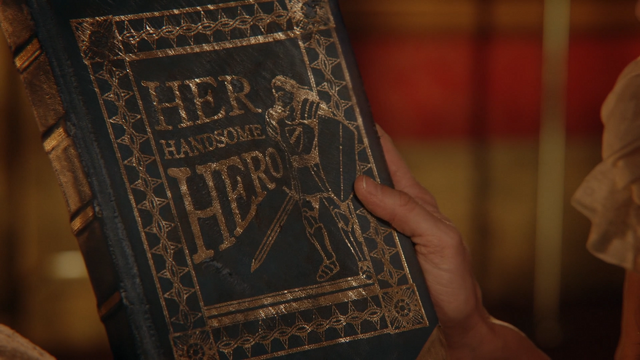 Fichier:6x09 Son Beau Héros roman couverture main Belle.png