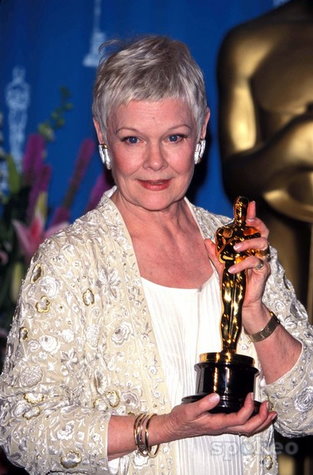Judi Dench holding an Oscar.