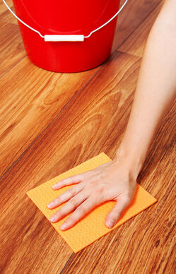Woman s hand cleaning the floor with yellow sponge