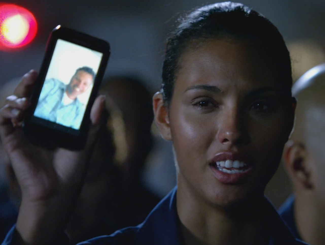 Maya Gibson holding a phone in a scene from the 2014-2018 tv series, The Last Ship