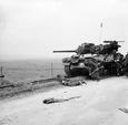 Commonwealth troops take cover by an M10 Tank Destroyer, Normandy 1944